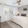 a bedroom with a fan and lots of natural light