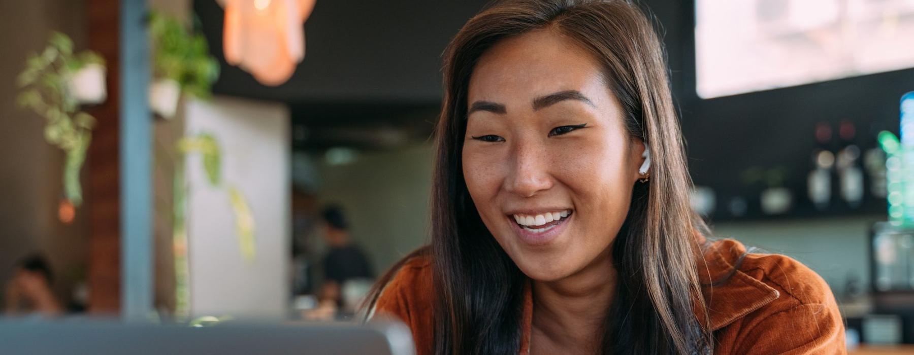 a woman smiling while working on laptop